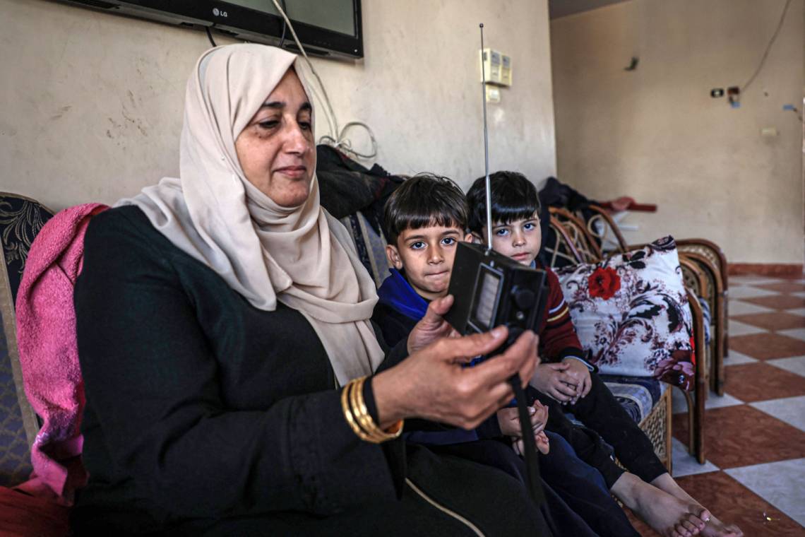 A Palestinian woman listens to the radio in Rafah in December 2023, during the war between Israel and Hamas.